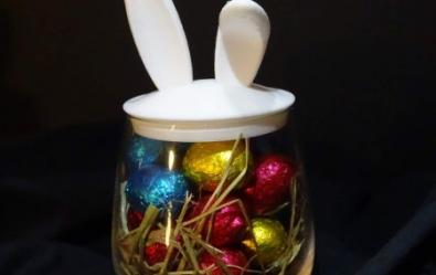 Verre avec des oreilles de lapin fourni avec des œufs en chocolat.